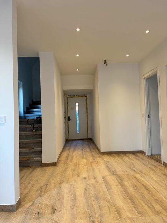 Hall med nytt golv i trälook och trappa
